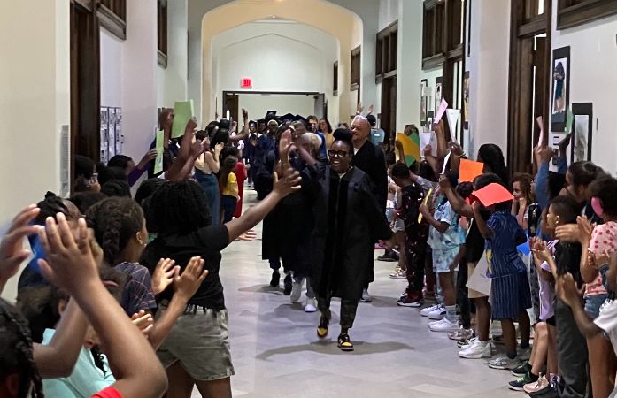  Students and staff cheering as the seniors walk down the hall